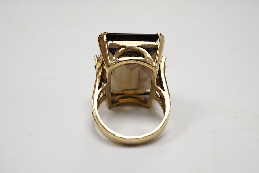 A 9ct and large single stone emerald cut smoky quartz set dress ring, size P, gross weight 14.9 grams. Condition - good